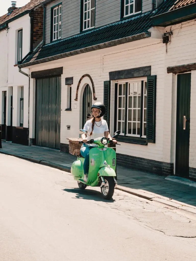 vrouw die op een Vespa rijdt in Brugge