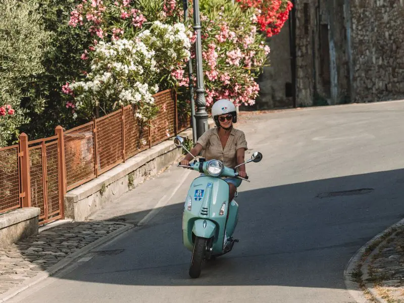 Blauwe Vespa die rondrijdt in Toscane