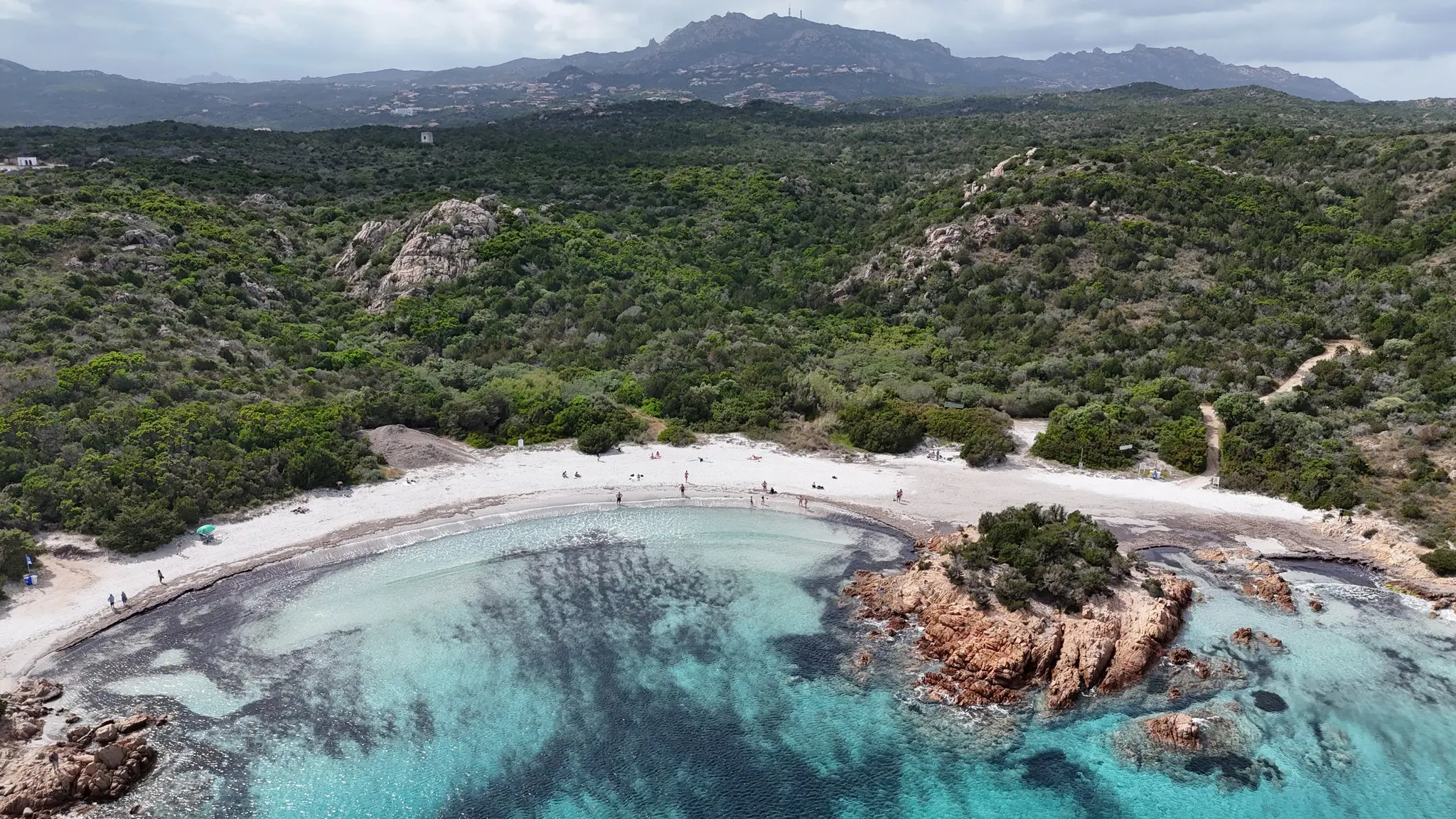 dronebeelden van een wit zandstrand met helder turquoise water