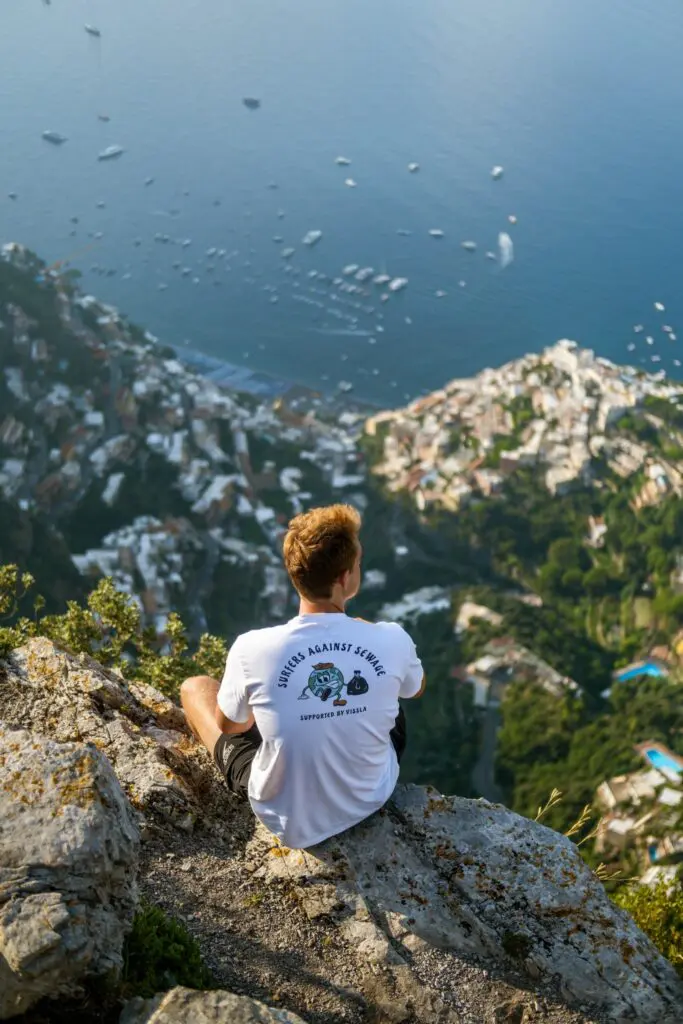 man on cliff overlooking Positano, Amalfi Coast
