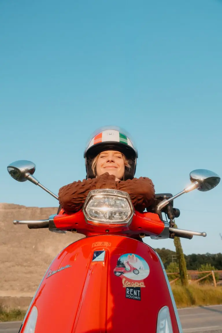 vrouw met helm op een rode Vespa-scooter in Veneto