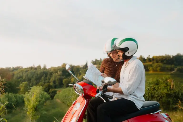 stel op een rode Vespa-scooter kijkt naar een kaart in Veneto