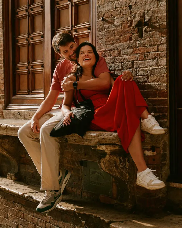 happy couple sitting on stone steps in Tuscany