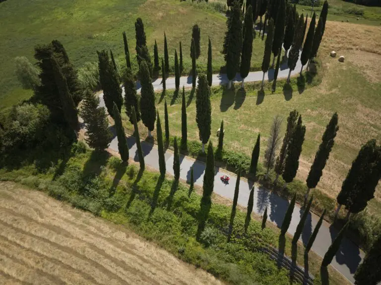 drone shot of a red scooter on a winding road in Tuscany