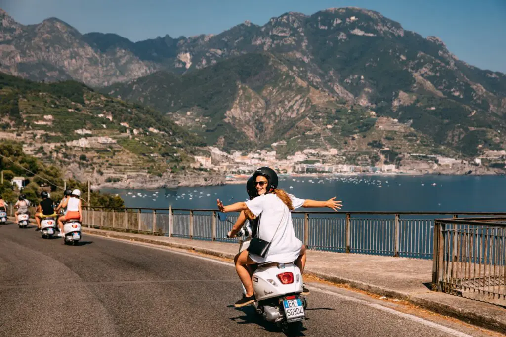 group of friends riding Vespas on the Amalfi Coast