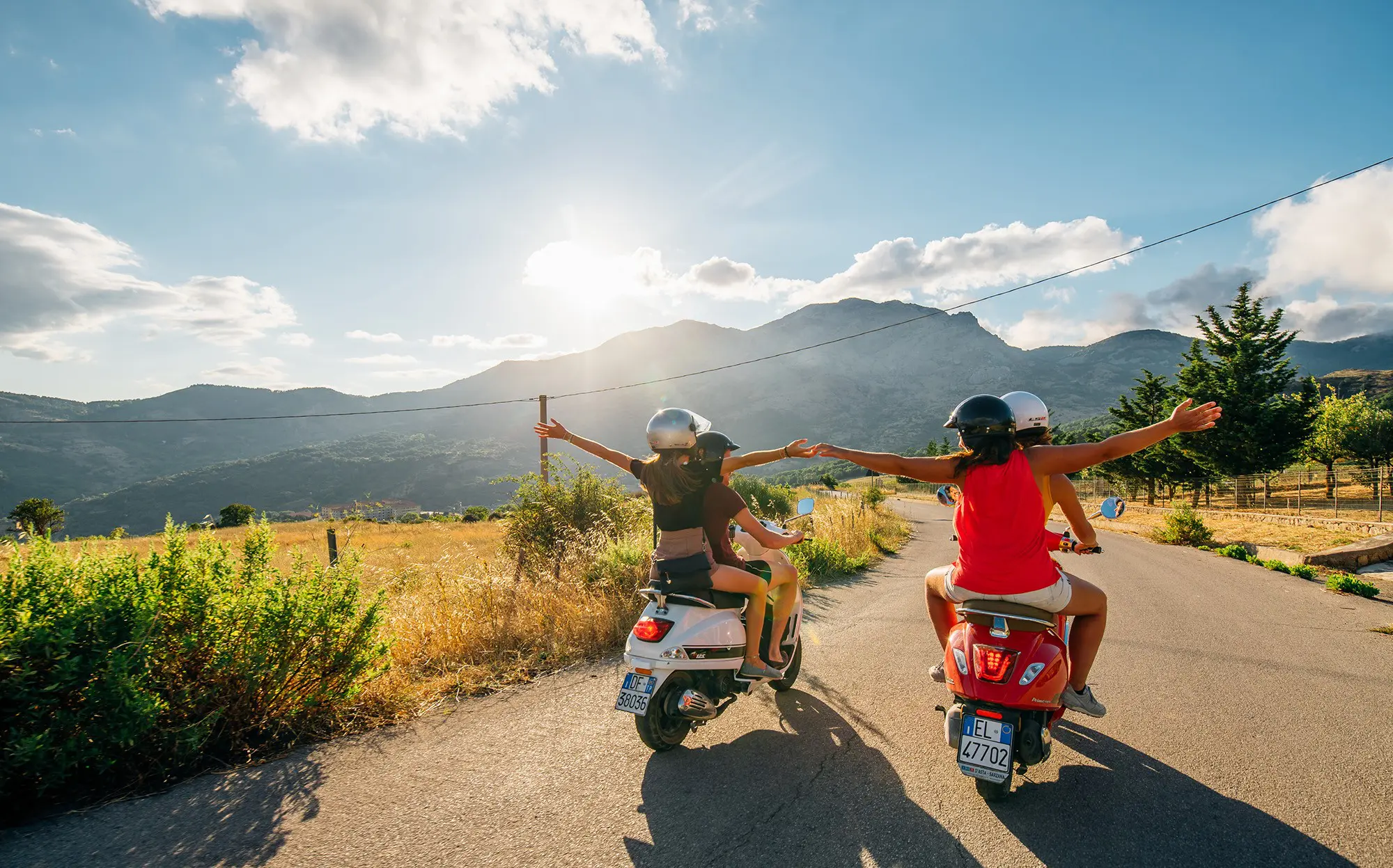 vrienden op Vespa-scooters op een schilderachtige weg in Sicilië