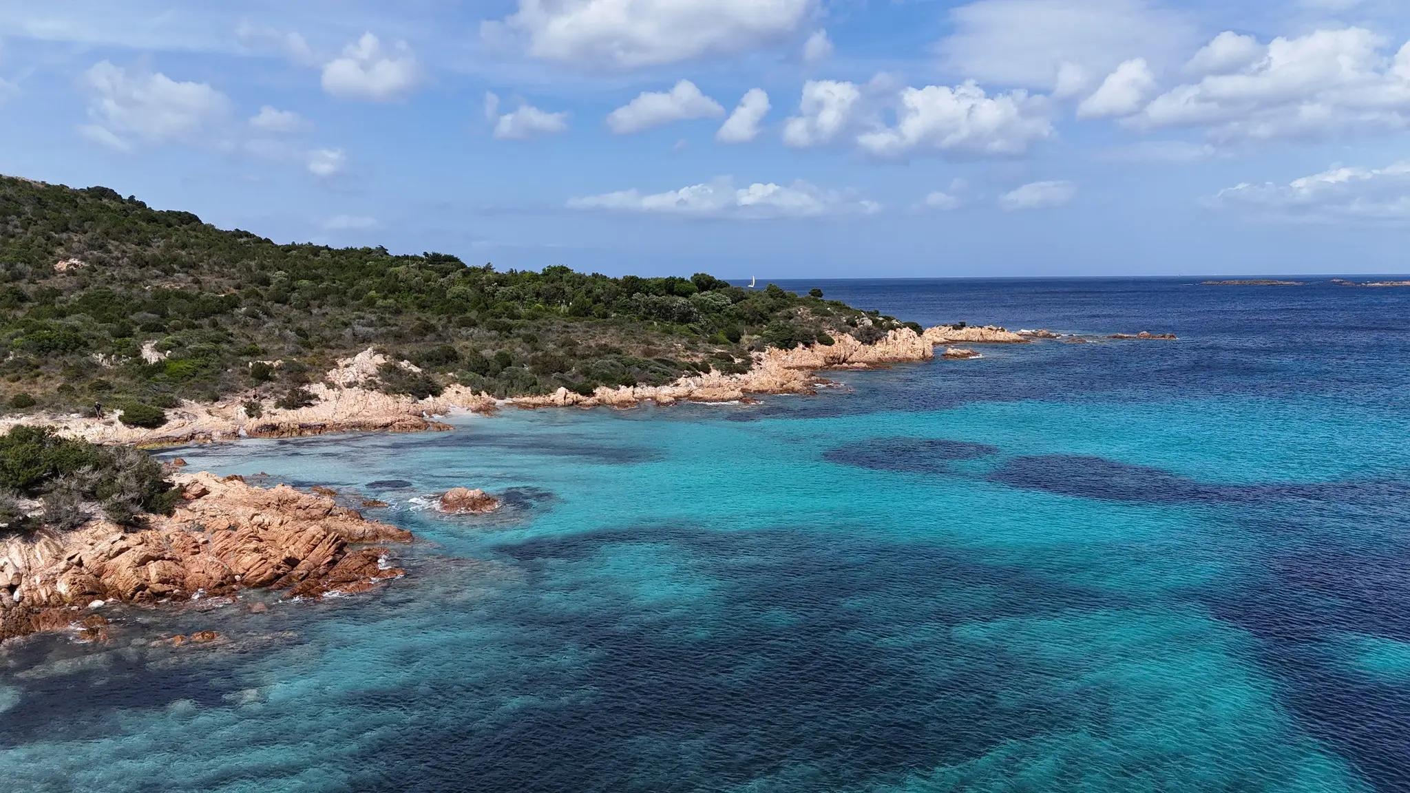 dronefoto van de turquoise kust van Sardinië met rotsachtige oevers