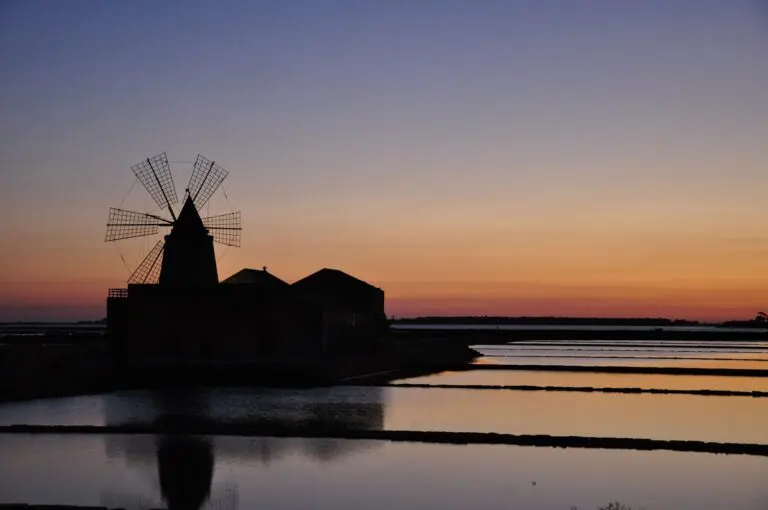 windmill silhouette at sunset over salt pans in Marsala, Sicily