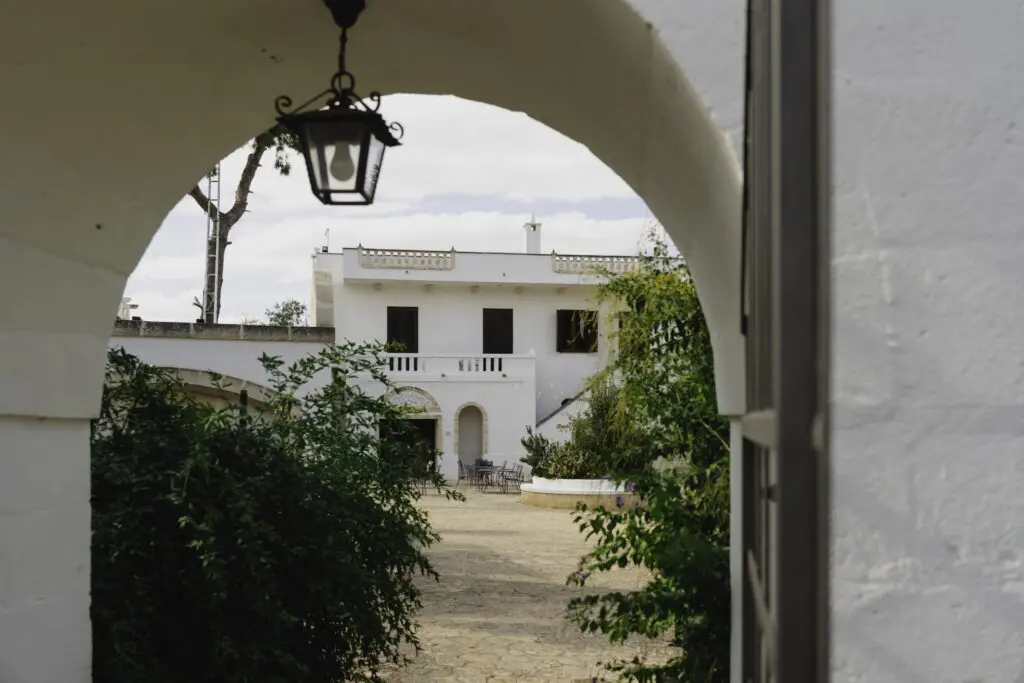 courtyard of a white building with an archway and hanging lamp