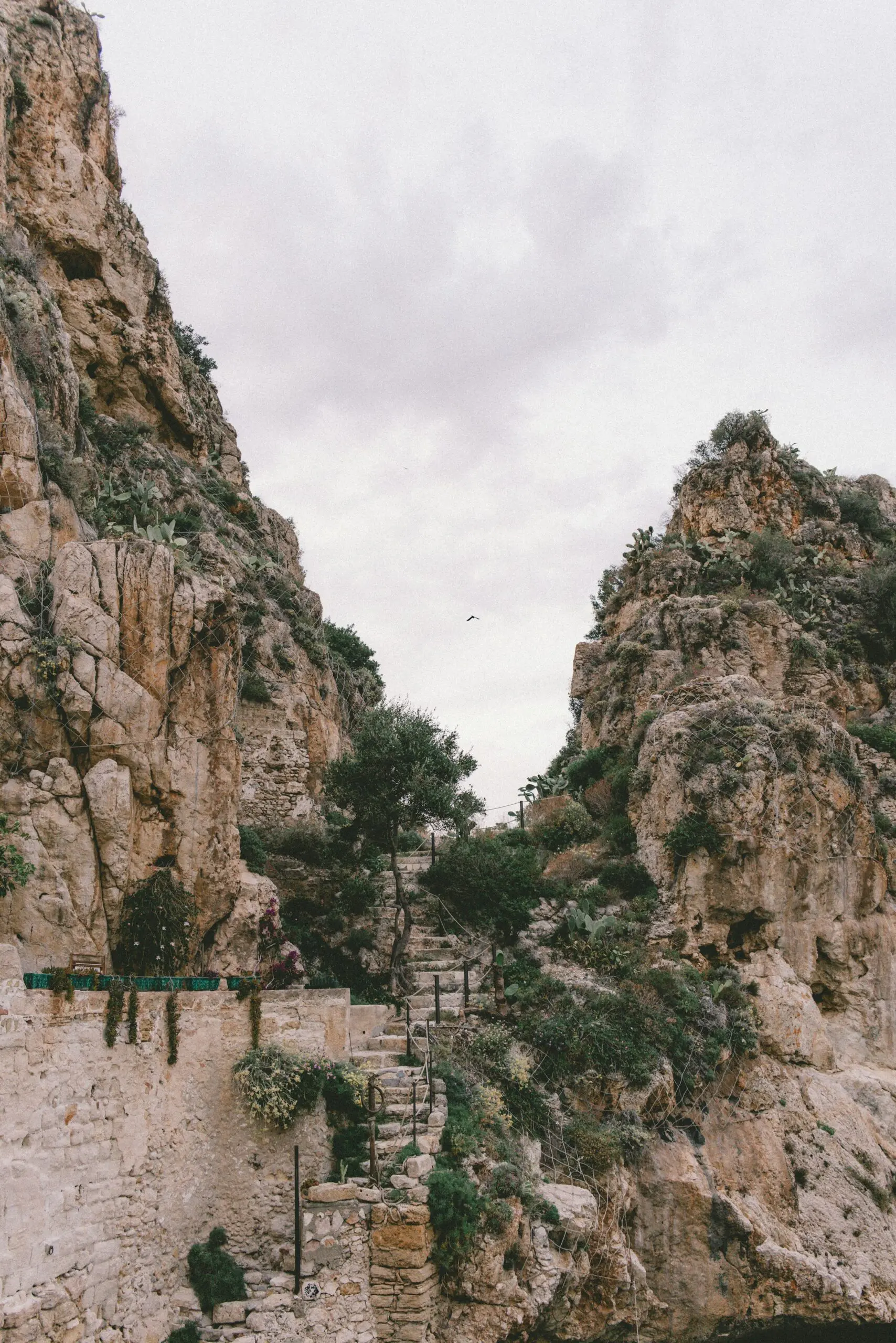 A rocky cliff with stairs leading up to it