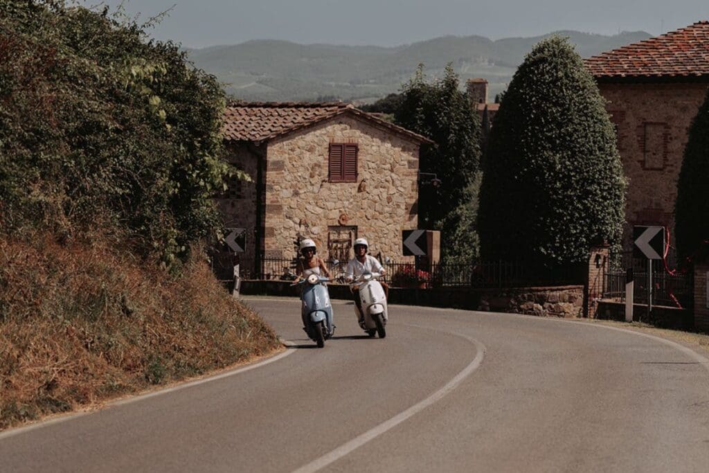 twee mensen op twee vespa's op de weg