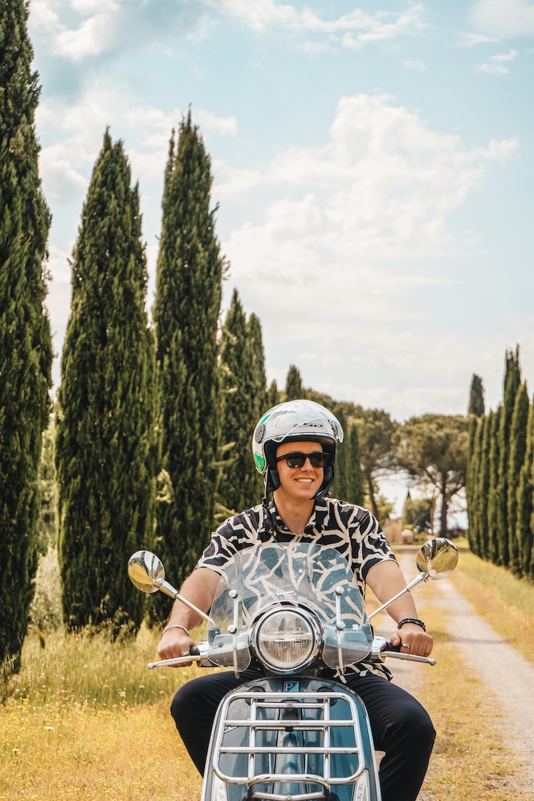 man op vespa in Toscane cipressen Toscane vespa rijder tussen cipressenbomen