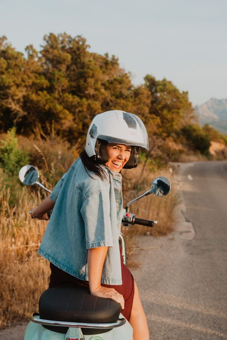 vrouw met helm op scooter op een weg in Sardinië