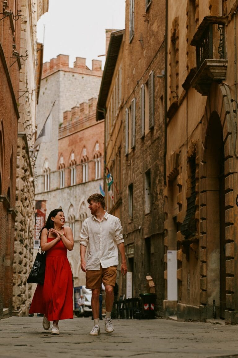 stel dat door een smalle straat in Siena loopt en lacht
