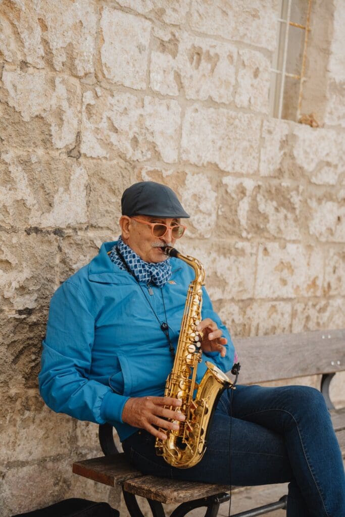 man die saxofoon speelt op een bankje in Puglia