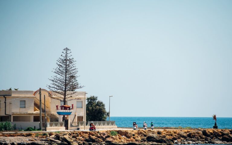 vespa riders on coastal road in Sicily, Italy